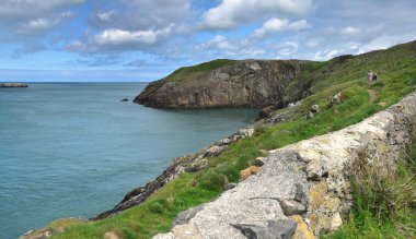 Cemaes Körfezi, Anglesey - 25 Haziran 2025: Cemaes Körfezi kayalıklarını keşfeden iki kadın