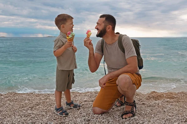 快乐家庭的暑假 儿子和父亲在海上吃冰淇淋 暑假快乐的生活方式童年的概念 — 图库照片