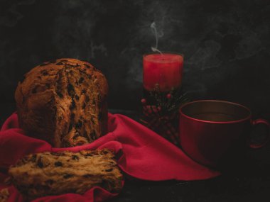 Pannetona çay ve bir mum ile en sağda siyah beton arka planda