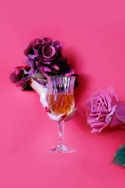 Trend paper whole woman hand with a glass of liquor . Holiday celebration concept