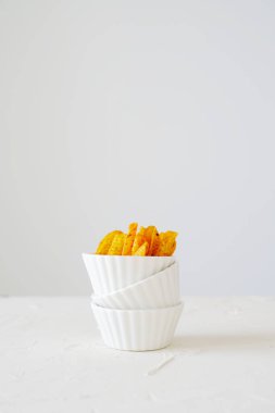 Tortilla chips prepared for a party snack. White kitchen