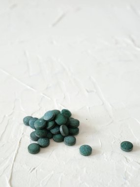 Green algae in pills spirulina on white background superfood. 