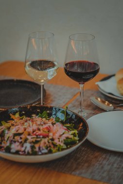 Italian restaurant table with dinner of pasta salad and a glass of wine. Pleasant atmosphere
