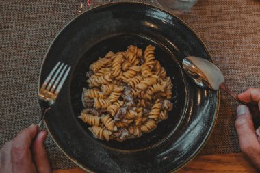 Italian restaurant table with dinner of pasta salad and a glass of wine. Pleasant atmosphere