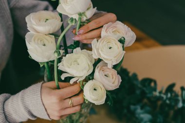 Small business flower shop florist hands with a bouquet of fresh white ranunculus 