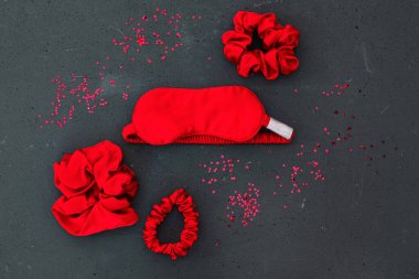 Üst görünüm kırmızı aksesuarlar gri arka planda uyku maskesi düz yatıyordu
