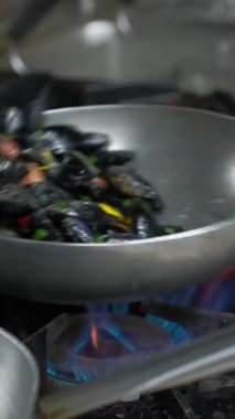 Midye hazırlığı. Şef bir restoranın mutfağında beyaz şarapla midye pişiriyor. Ağır çekim. Kapatın. Yüksek kaliteli FullHD görüntüler