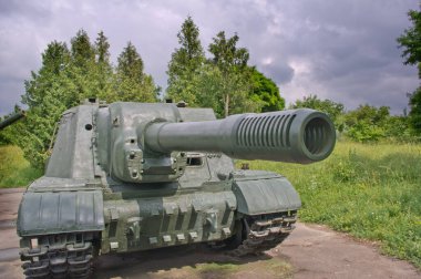 Yazın arka planına ve dramatik gökyüzüne karşı eski bir tank.