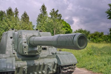 Yazın arka planına ve dramatik gökyüzüne karşı eski bir tank..