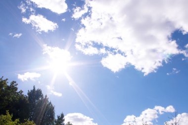 Parlak güneş ve bulutlu mavi gökyüzü. Anormal ısı kavramı