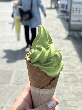 Yeşil bir yaprağın arka planında waffle külahında dondurma.