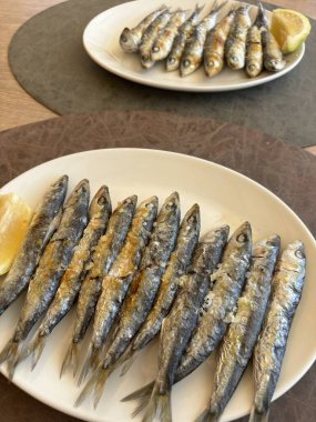 Baharatlı ızgara uskumru ve beyaz tabakta limon..