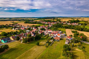 Almanya 'da çayırlarla, tarlalarla ve ormanlarla çevrili bir Alman köyünün manzarası.