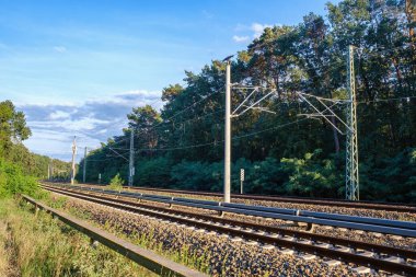 Railway tracks view. Railway rails and embankment surrounded by forest. Railroad