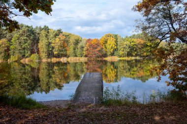 Beautiful sunset over lake with wooden pier.