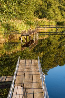 Beautiful sunset over lake with wooden pier.