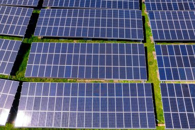 Fotovoltaik panellerle güneş enerjisini tarım arazilerindeki yeşil enerji için elektriğe dönüştüren bir güneş çiftliğinin üzerinde uçmak