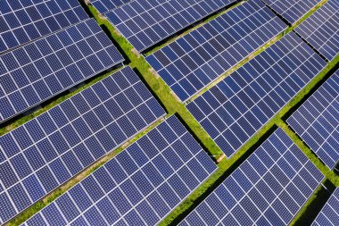 Fotovoltaik panellerle güneş enerjisini tarım arazilerindeki yeşil enerji için elektriğe dönüştüren bir güneş çiftliğinin üzerinde uçmak