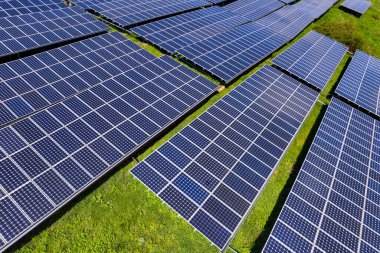 Fotovoltaik panellerle güneş enerjisini tarım arazilerindeki yeşil enerji için elektriğe dönüştüren bir güneş çiftliğinin üzerinde uçmak