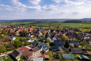 Etrafı güzel tepelik yeşil manzaralarla çevrili renkli bir gündoğumu, hava görüntüleri. Almanya.