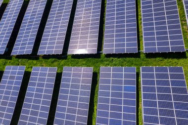 Fotovoltaik panellerle güneş enerjisini tarım arazilerindeki yeşil enerji için elektriğe dönüştüren bir güneş çiftliğinin üzerinde uçmak