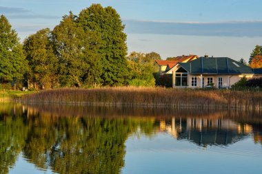 Gölün doğal manzarası, yüksek çözünürlüklü dalgaların sonbahar ormanının arka planına karşı hareketi. Bulutların su dalgaları üzerindeki yansıması. Almanya.