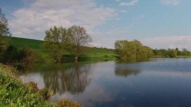 Göl ve yeşil orman ağaçları. Sudaki orman yansıması. Sihirli atmosfer.