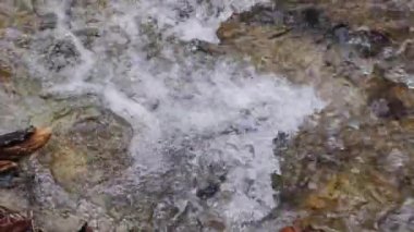 Dağ nehri suyu ve yavaş çekim yakın çekim. Nehir taşlarını akan suyla kapatın..
