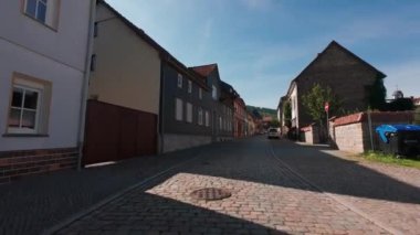 Almanya - 08 09 2023. Birinci şahıs, eski bir Alman taşra kasabasının sokaklarında motosikletle geziyor..