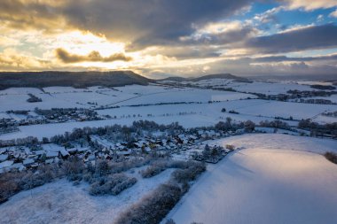 Kış. Gün batımında yoğun karla kaplı küçük bir Alman dağ köyünün hava manzarası. Almanya.