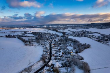 Kış. Gün batımında yoğun karla kaplı küçük bir Alman dağ köyünün hava manzarası. Almanya.