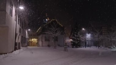 Geceleri taşralı bir Alman kasabasında kar yağıyor. Noel gecesi. Yüksek kalite 4k görüntü