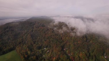 Almanya 'daki küçük, pitoresk bir dağ kasabasının havadan görünüşü, sisle kaplanmış vadiler ve dağlar. Yüksek kalite 4k görüntü