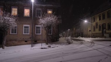 Geceleri taşralı bir Alman kasabasında kar yağıyor. Noel gecesi. 4K hig tanımlama videosu.