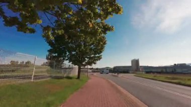 Sonbaharda kırsal bir kasaba yolunda araba sürmek. FPV yol boyunca gidiyor. Sokakta araba kullanan ilk kişi. Almanya.