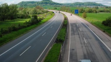 Güneşli bir günde iki yönlü yolda taşımacılık trafiği. Her iki şeritte de altı şeritli iki şeritli bir yol. Almanya.