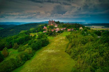 Görkemli yeşil tarlalar ve görkemli manzaralar arasında zarif bir şekilde yerleşmiş tarihi bir kalenin çarpıcı bir şekilde ele geçirilmesi. Hanstein Kalesi, Almanya.