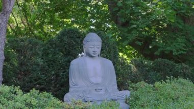 Buda. Yeşil bir parkta Buda 'nın taş heykeli.