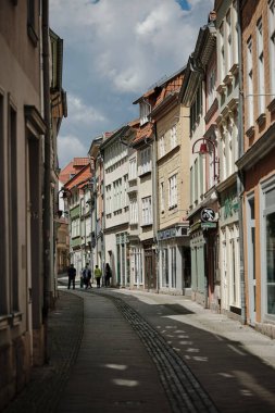 Muhlhausen, Almanya-10 07 2024. Güneşli bir günde canlı ve renkli bir mimarinin sergilendiği pitoresk bir kasabada büyüleyici ve antika bir cadde.