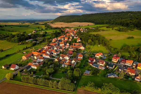 Büyüleyici Alman köyü, gür bir vadi boyunca yayılıyor, canlı çatıları ile mavi gökyüzünün altında, tüylü bulutlarla süslenmiş manzarayı noktalıyor. Doğa her yönde gelişir. Almanya.