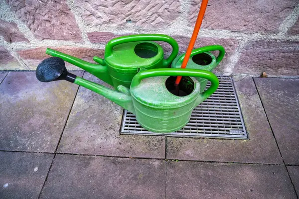 Taş bir duvarın karşısında duran plastik bahçe fıskiyeleri. Bir ülke konsepti.