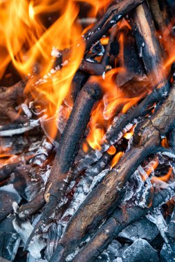Şömine yanan odunlar, parlayan közler, rahat sıcaklık, rahatlatıcı atmosfer.