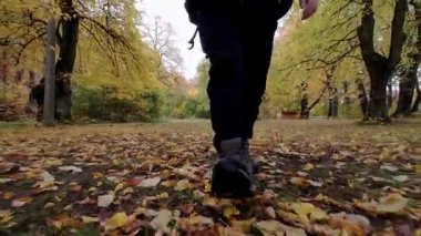 Uzay Yolu 'ndaki bir adamın ayaklarının yakın plan görüntüsü Düşen botların üzerinden yürümesi Ormandaki Yapraklar.