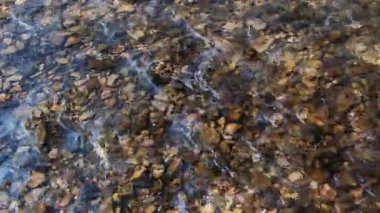 Taş kayaların arasından akan temiz akarsu taştan dipte akan bereketli nehirler. Yaz günü su sıçrayan vahşi dağ nehri. Su altı kabarcıkları. 4K.