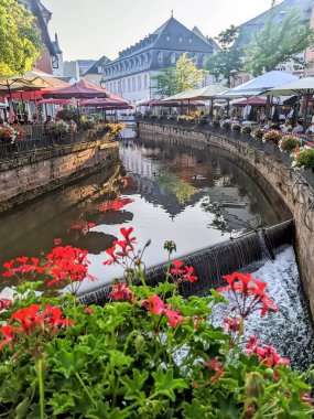 Almanya 'nın Saarburg kentinin nehir kıyısında restoranları olan ana cadde.