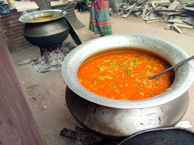 Khichuri ve sebzeler büyük bir tavada halk için yenir.