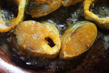 Lezzetli ve sağlıklı kızarmış balık parçaları köri ve yemek için demir tavada.