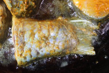 Lezzetli ve sağlıklı kızarmış balık parçaları köri ve yemek için demir tavada.