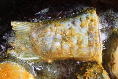 Lezzetli ve sağlıklı kızarmış balık parçaları köri ve yemek için demir tavada.