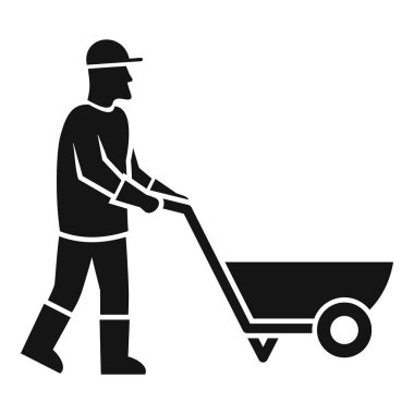 Çizme ve eldiven giyen inşaat işçisi boş bir el arabasını itiyor.